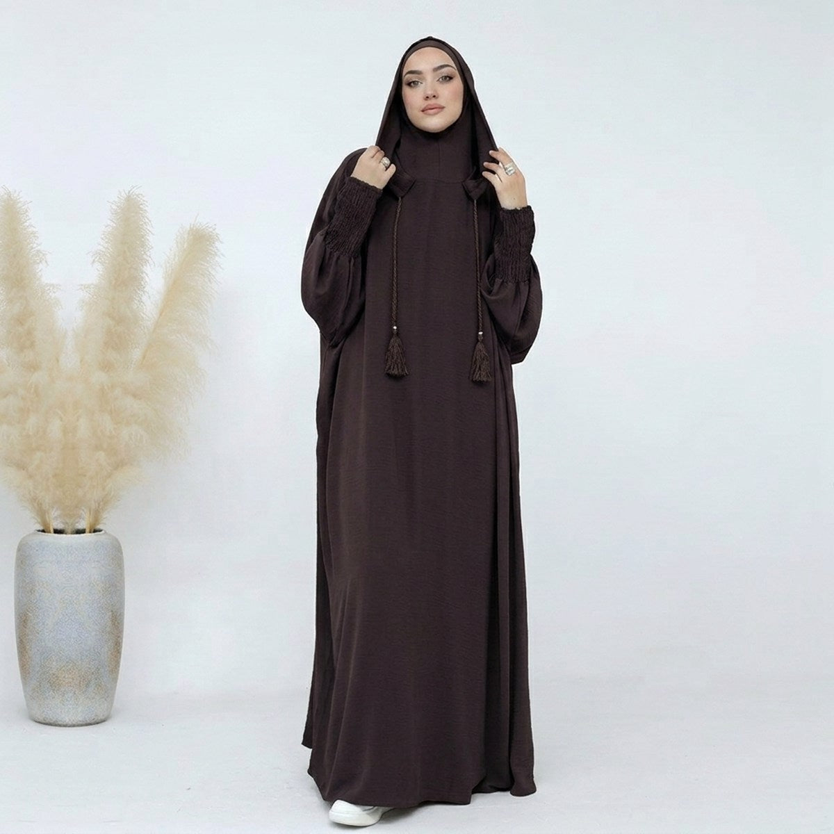 Hooded abaya in dark coffee, full-length front view, soft drape with tassel detail