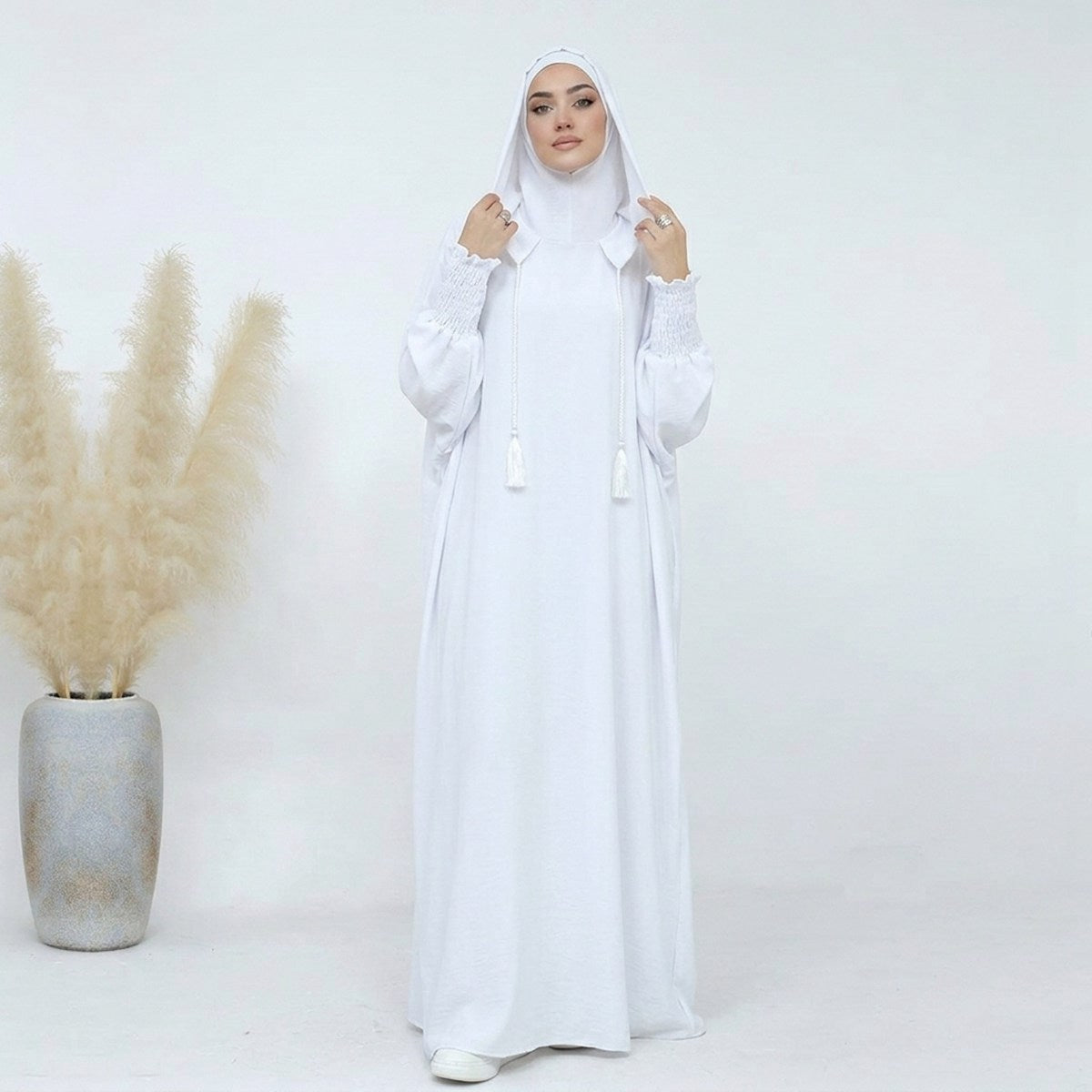 White hooded prayer dress, front view, voluminous silhouette with braided tassel ties